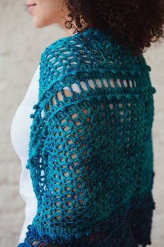 a woman wearing a blue crocheted shawl