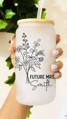 a woman holding a white mason jar with flowers on it and the words, future mrs smith