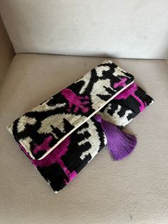 This uzbek patchwork clutch bag with tassel  will make a great birthday gift for the ladies in your family. It combines the modern and traditional, the practical and artistic. Use it as an accessory that will turn heads and make every outfit stand out. The bag is decorated with a fashionable tassel.Put your keys, phone and some special secret things in it and you'll complete that chic look you need for that big occasion or long-awaited party.  Who is this clutch for?  Everyone, really. Wholesalers, retailers, individual customers.   And for those who need a fresh idea for a Mother's day gift :)  Product details: *Outer:  silk velvet ikat fabric *Inner: organic cotton lining *Length: 12  inches / 30 cm approx. *Width: 7   inches / 17 cm approx. *Magnetic snap closure. *Dyes: Organic, vegeta Rectangular Evening Bag With Tassels, Rectangular Tassel Clutch For Parties, Chic Purple Clutch As A Gift, Rectangular Party Clutch With Tassels, Rectangular Tasseled Clutch As Gift, Rectangular Purple Clutch For Gifts, Purple Rectangular Clutch For Gifts, Rectangular Purple Clutch Gift, Patchwork Clutch