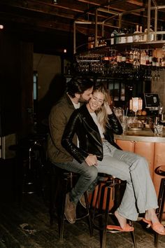 a man and woman are sitting at a bar smiling for the camera while they look into each others eyes