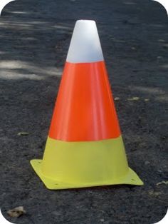 an orange and white cone sitting on the ground