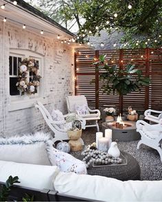 an outdoor living room with white furniture and string lights