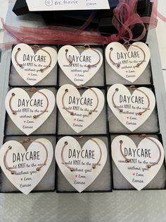 six heart shaped necklaces in a gift box with ribbons and tags on them that say day care