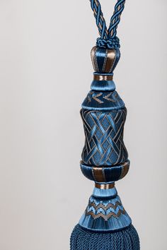 a blue tasseled vase with two braids on the top and one in the middle