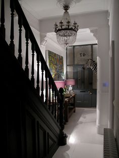 a hallway with a chandelier and zebra print on the wall