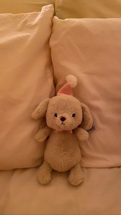 a stuffed animal sitting on top of pillows