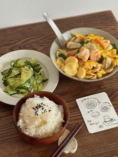 two bowls of food on a table with chopsticks next to one bowl filled with rice and vegetables