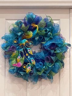 a blue and green wreath hanging on the front door