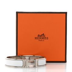 This is an authentic HERMES Enamel Narrow Clic Clac H Bracelet PM in white. This unisex bracelet features a brushed palladium band with a hinge on one side and opens with a swivel Hermes "H" on the prominent side. Around the band is a strip of matte white enameling set in the metal. H Bracelet, Unisex Bracelets, Siding, Band, Bracelet, White