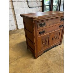 an old wooden dresser sitting in front of a brick wall with mirrors on it's sides