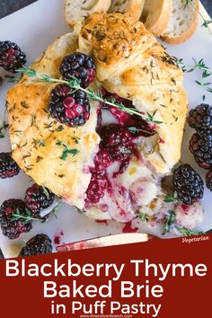 blackberry thyme baked brie in puff pastry on a white plate with fresh berries