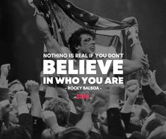 a man holding up an american flag with the words believe in who you are above him