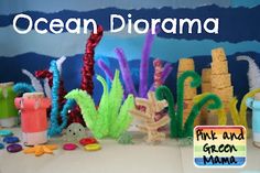 an ocean diorama is displayed on a table with toys and other items around it