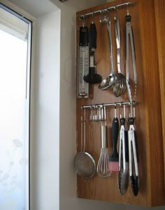 a wooden shelf holding various kitchen utensils