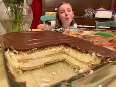 a woman sitting at a table with a cake in front of her