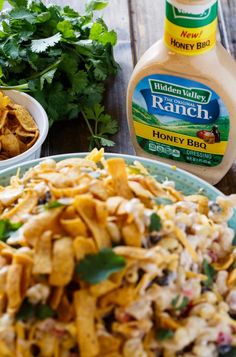 a bowl of food with ranch dressing next to it and other ingredients on the table