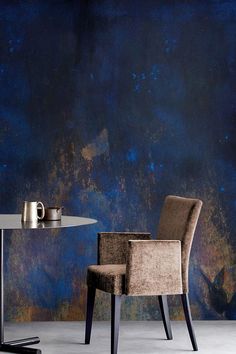 two chairs and a table in front of a blue wall