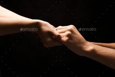 two people holding hands in front of a black background - stock photo - images and clippings