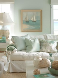 a living room filled with white furniture and lots of sea shells on top of it