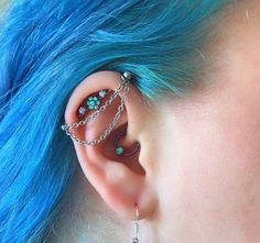 a woman with blue hair has piercings on her ear