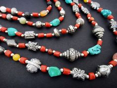 This multi strand beaded necklace is comprised of five strands of short coral tube beads, tumbled Tibetan turquoise, tumbled carnelian, yellow jade and hand-made Tibetan sterling silver beads. A simple chain and handmade hook clasp finish this multi strand necklace in the back. The shortest strand measures 16 inches long. The longest strand measures 30 inches long. Bohemian Jewelry With Polished Beads, Bohemian Jewelry With Polished Tumbled Beads, Bohemian Tumbled Polished Beads Jewelry, Bohemian Handmade Tumbled Necklace, Bohemian Long Multi-strand Necklace With Faceted Beads, Unique Red Multi-strand Beaded Necklace, Red Multi-strand Gemstone Beads Necklace, Multicolor Turquoise Necklace With Hand-strung Beads, Frog Necklace