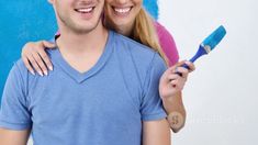 a man holding a toothbrush and smiling at the camera while standing next to a woman