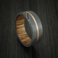 a wooden ring with silver and wood inlays on it's side, sitting on a table