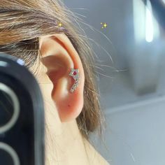 a woman's ear is shown with a small diamond ring on top of it