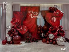 a red and silver christmas display in a room with balloons, balls, and decorations