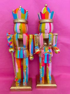 two colorful wooden toy figures standing next to each other