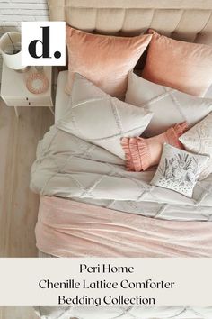 a bed with pink and white pillows on top of it next to a night stand