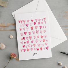 two cards with hearts on them, one has the word i love you written in it