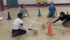 children are playing with balls in an indoor gym