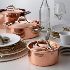 copper pots and pans are sitting on the table