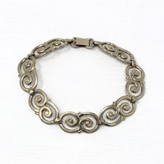 "Lovely vintage circa 1940s era 14k gold filled sterling silver bracelet! This classic bracelet is comprised of unique scroll style panels, and secures with a fold over clasp. A stylish piece of signed vintage jewelry!  ERA - Circa 1940s - Retro METAL / MATERIAL - 14k gold filled on sterling silver  MARKINGS / HISTORY - Bracelet is marked \"SYMMETALIC STERLING+14k\" Symmetalic was a trade name of the W. E. Richards Company of North Attleboro, Massachusetts, which was first used in the mid 1930s Vintage Bronze 14k Gold Jewelry, Antique Metal Jewelry With Polished Finish, Retro Brass Jewelry For Formal Occasions, Vintage Brass Gold Bracelet For Formal Occasions, Antique Sterling Silver Bracelet, Sterling Silver Vintage Bracelet For Formal Occasions, Vintage Sterling Silver Bracelets For Formal Occasions, Elegant Brass Bracelets With Antique Finish, Vintage Sterling Silver Bracelet As Gift