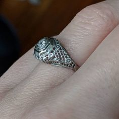 This Art Deco engagement ring has no shortage of charming details. Lacey, beaded scrolls and criss-cross patterns cover the whole top of the ring making it light and airy. It is crowned with a glittering diamond held in place by 8 tiny prongs. It would make an excellent engagement or vintage statement piece! * Art Deco 1930's approximately * 18K White gold * .07ct (approximate) Transitional cut diamond * Size 6.5 - Can be resized within a couple sizes * Very good/excellent condition - Some wear Formal White Gold Filigree Jewelry, Classic White Gold Jewelry With Rose Cut Diamonds, Heirloom White Gold Diamond-cut Jewelry, Heirloom White Gold Jewelry With Diamond Cut, Fine Jewelry Platinum Filigree, White Gold Round Filigree Jewelry, Classic Platinum Jewelry With Rose Cut Diamonds, Formal 14k White Gold Filigree Ring, Intricate Platinum Jewelry Gift