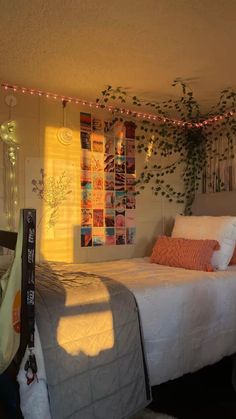 a bed sitting in a bedroom next to a wall with pictures on it and lights hanging from the ceiling