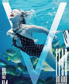 the cover of v magazine featuring a woman in a swimsuit swimming under water and surrounded by fish