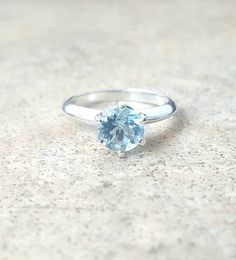 This Genuine Aquamarine Ring is set in a six-pronged setting is securely set,  and handmade by me.The Aquamarine is 6mm round natural color, genuine Brazilian Aquamarine.This gorgeous Aquamarine solitaire ring is shown in Sterling Silver and can be made in Gold. It makes the perfect Aquamarine engagement ring. This real Aquamarine ring can be made qith a smaller or bigger natural Blue Aquamarine gemstone.The  real Aquamarine is a beautiful sea blue, as the name implies.  Aquamarine is the births Timeless Sapphire Solitaire Promise Ring, Solitaire Ring With Round Stone For Promise, Round Cut Topaz Solitaire Promise Ring, Round Cut Solitaire Topaz Promise Ring, Topaz Ring With Prong Setting For Promise, Topaz Ring With Prong Setting For Promise, Round Cut, Solitaire Birthstone Promise Ring, Fine Jewelry Solitaire Topaz Ring With Round Cut, White Gold Topaz Solitaire Ring