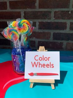 there is a sign that says color wheels and lollipops in a jar