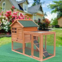 a small wooden chicken coop in front of a house