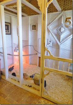 the inside of a chicken coop with two chickens in it's cages and one on the floor