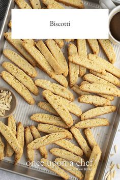 biscotti on a baking sheet with coffee in the background and text overlay that reads, biscotti one upon a chef