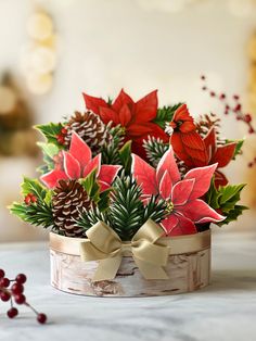 a wooden container filled with poinsettia and pine cones on top of a table