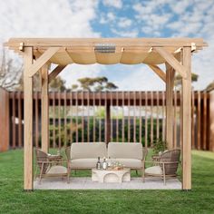 a wooden gazebo sitting on top of a lush green field next to a fire pit