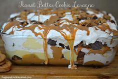 a dessert dish with cookies and caramel drizzled on top, sitting on a cutting board