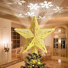 a lighted christmas tree in the middle of a living room with a star on top