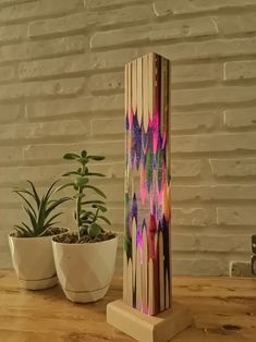 a wooden stand with some plants on top of it next to a potted plant