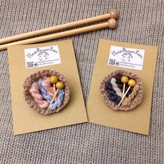 two small knitted pins sitting on top of brown paper