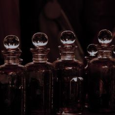 several glass bottles with metal caps sitting on a table